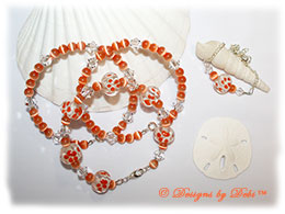 Designs by Debi Handmade Jewelry Aloha Collection Ornge Bangle Trio and Anklet Set. Features orange aloha floral glass rondelles, orange round cat's eye beads, swarovski clear crystal bicones and matching anklet.