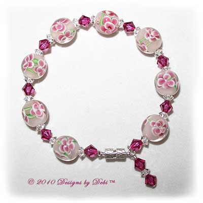 Designs by Debi Handmade Jewelry Aloha Collection Pink Bangle Bracelet featuring raspberry aloha floral glass beads, swarovski crystal fuchsia bicones and clear spacers, a dangle and a magnetic clasp.