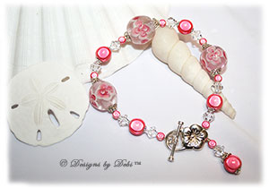 Designs by Debi Handmade Jewelry Aloha Collection Salmon Pink Bracelet featuring salmon pink aloha floral glass beads, swirled sterling silver bead caps, swarovski crystal clear bicones, salmon miracle beads, dangle and sterling flower toggle clasp.