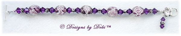 Designs by Debi Handmade Jewelry Aloha Collection Amethyst Bracelet featuring amethyst purple aloha floral glass beads, swarovski crystal amethyst bicones, silver flower spacers, a dangle and a sterling flower toggle clasp.