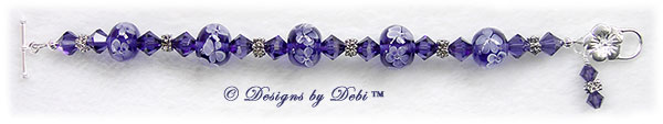 Designs by Debi Handmade Jewelry Aloha Collection Purple Bracelet featuring royal purple aloha floral handmade lampwork beads, swarovski crystal purple velvet bicones, silver flower spacers, a dangle and a sterling flower toggle clasp.