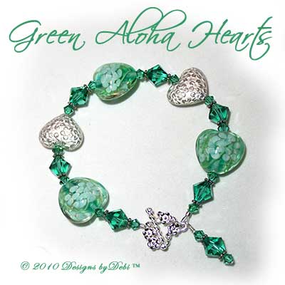Designs by Debi Handmade Jewelry Green Aloha Hearts Green Glass Hearts, Bali Silver Floral Heart Pillows and Swarovski Crystal Light Emerald Bicones Bracelet with a Sterling Silver Square Floral Toggle Clasp